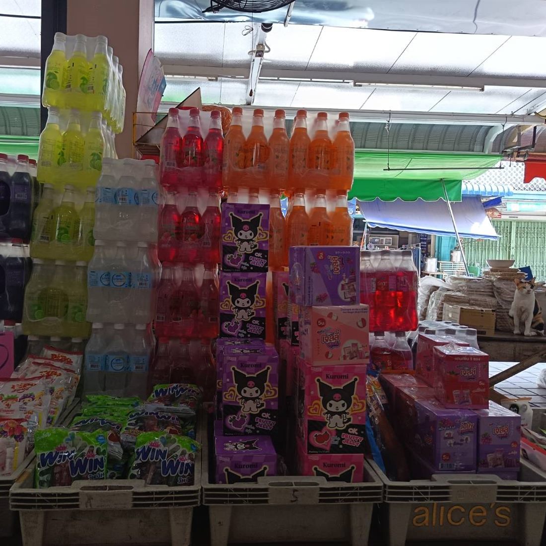 น้ำดื่มและน้ำหวานยกแพ็คตั้งซ้อนกันหน้าร้าน